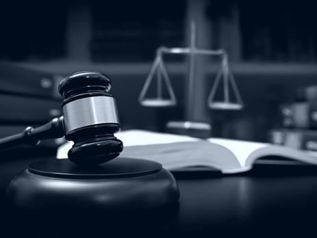 A gavel, scales and an open book on a desk