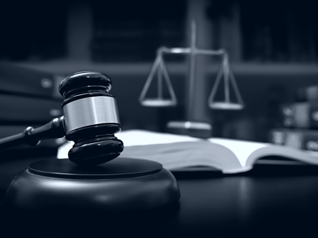 A gavel, scales and an open book on a desk